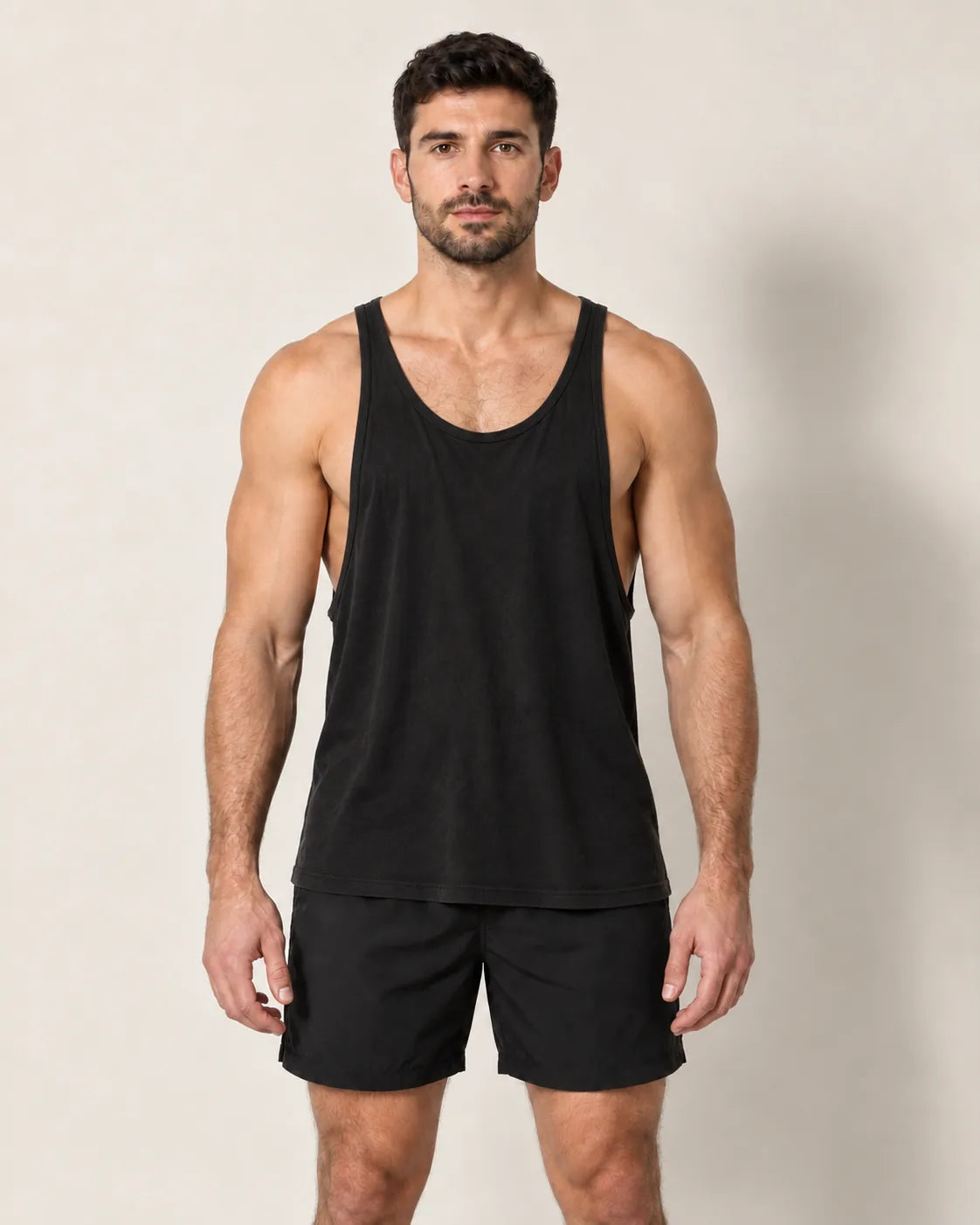 Standard-Tanktop von vorn getragen: tiefe Armausschnitte, die die Flanken freilegen, weiter Stoff, der über dem Bauch flattert und auf die Shorts fällt